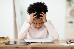 young mother working at desk as she researches neurodivelopmental disorder treatment programs.